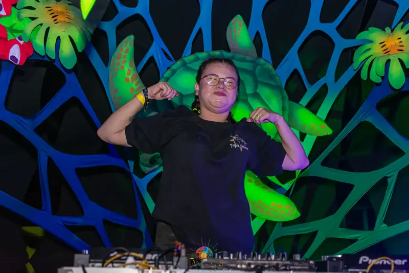 DJ com braço erguido, muita energia no set