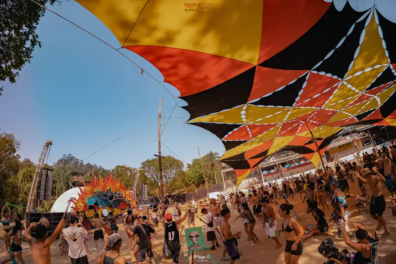 Público dançando sob a decoração de lonas ao ar livre